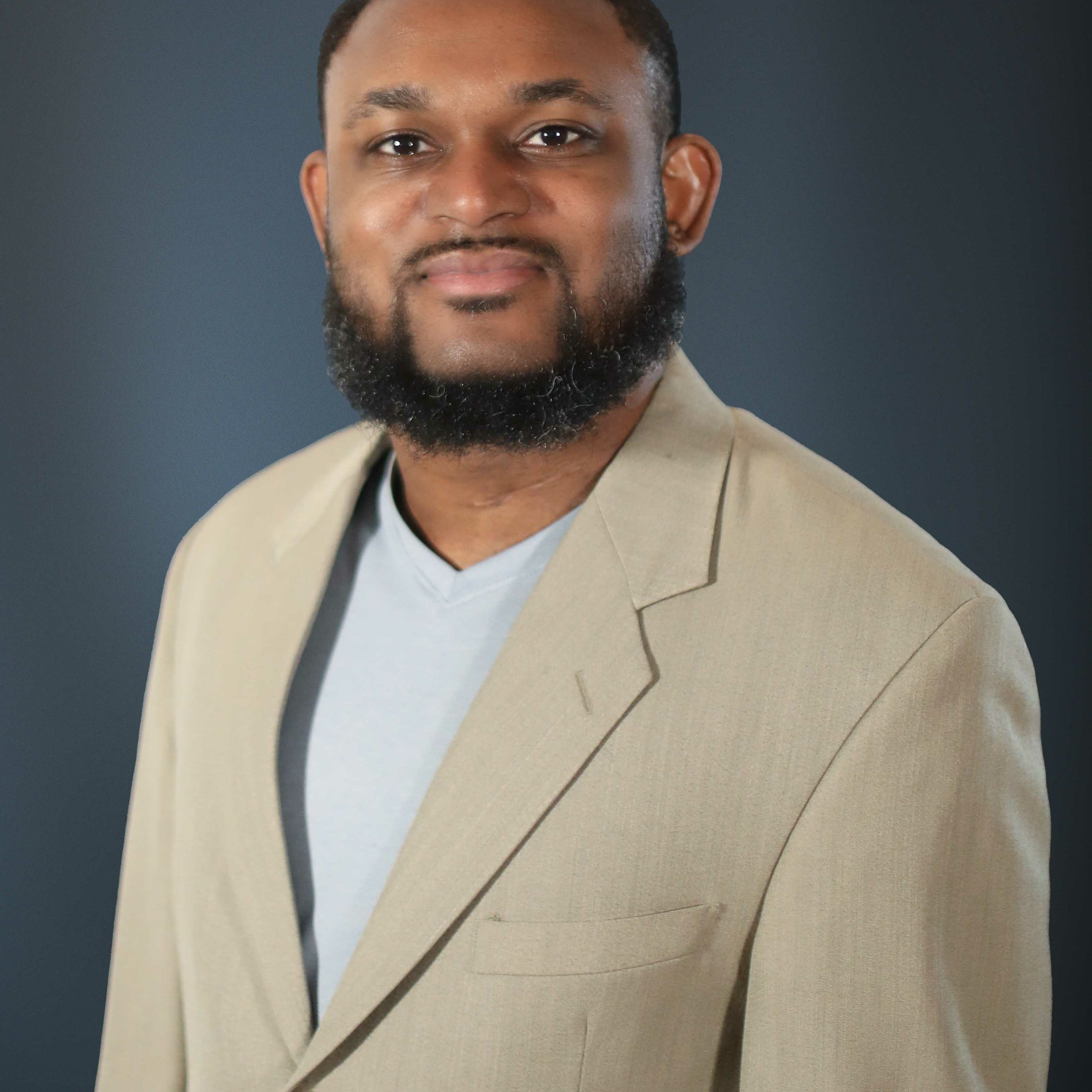 Mcfitz Pierre - 2161 x 2707 Man smiling in beige blazer education staff photo